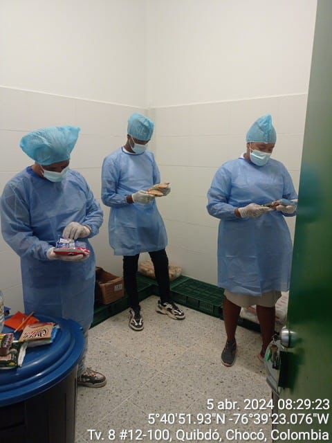 Tres profesionales en trajes de bioseguridad clasificando alimentos en instalaciones de Quibdó, Chocó